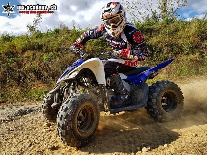 Quad fahren im Gelände: Fahrer auf seinem Quad, hinter ihm wirbelt eine Staubwolke auf