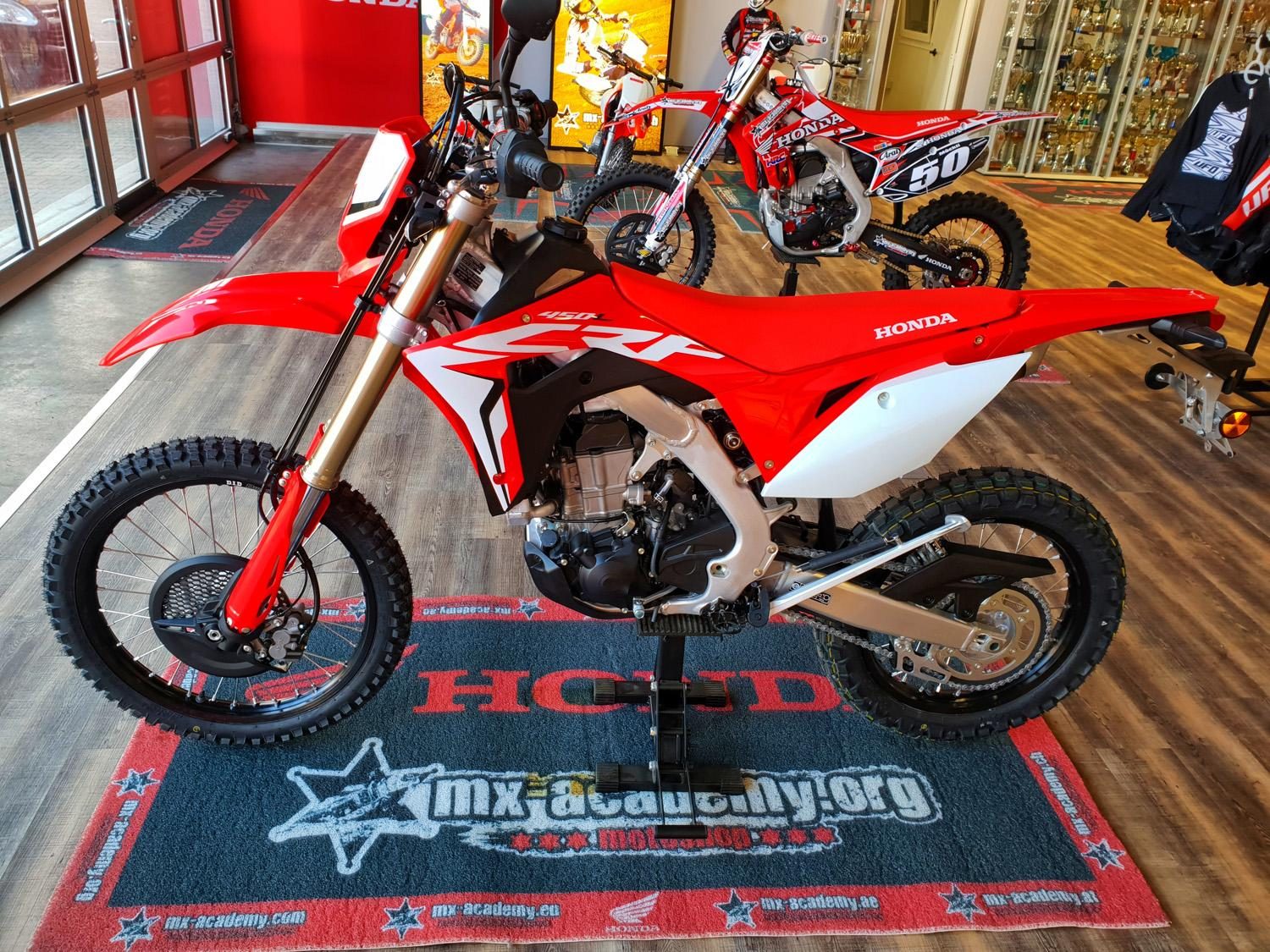 Honda CRF auf einem Teppich mit MX-Academy-Logo im Verkaufsraum – ein MX Bike zum Anschauen und Kaufen
