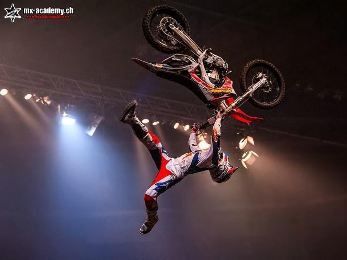FMX Freestyle in der Halle: Fahrer zeigt hoch in der Luft einen Trick mit dem Motorrad