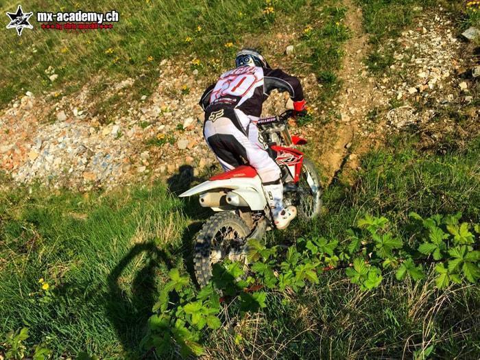 Fahrer auf einem Trail mitten im hohen Gras – Trails mit dem Motorrad erleben