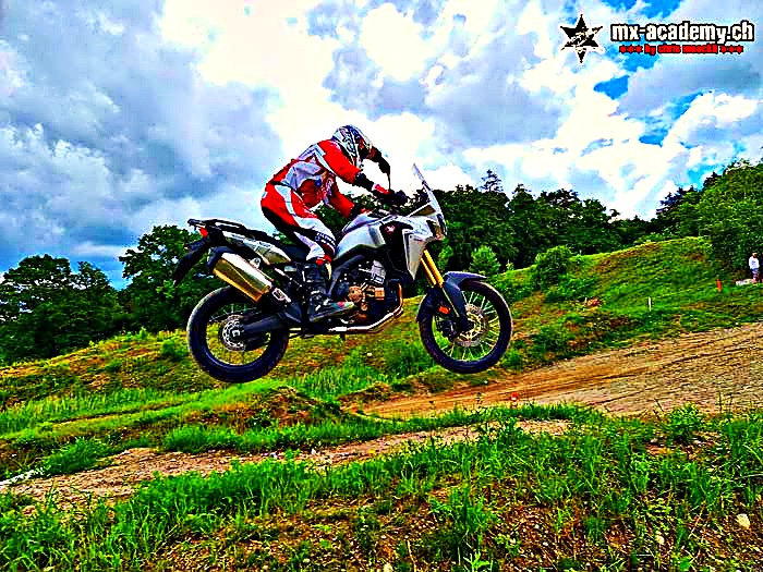 Fahrsicherheitstraining Motorrad: Reiseenduro im Sprung über einen Erdhügel