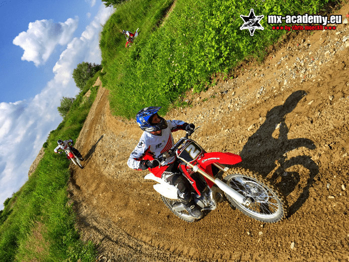 Fun Motocross: Ein Fahrer legt sich in die Kurve, sein Schatten fällt auf die Strecke