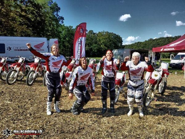 Vier Fahrerinnen in Honda-Trikots jubeln vor den Motorrädern und dem Honda-Zelt – ein Weihnachtsgeschenk zum Erleben