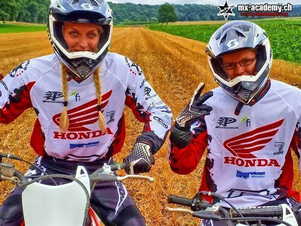 Zwei in Honda-Trikots: Fahrerin mit Zöpfen und Fahrer mit Brille – Motorradfahren bei der MX-Academy