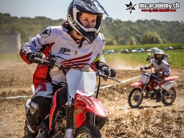 Motorrad fahren im Gelände: Fahrerin auf einer Honda, hinter ihr folgt ein Kind auf einem kleinen Bike