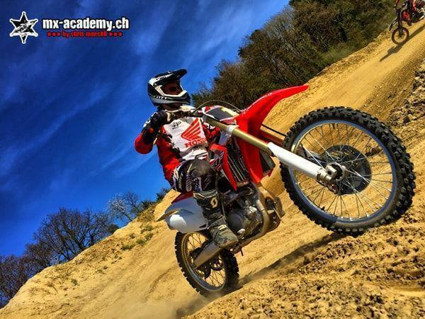 Steiler Sandhang: Fahrer auf einer Honda fährt hinauf, das Vorderrad hebt dabei ab