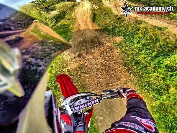 Aus der Helmkamera: Blick über den Lenker auf einen Sprunghügel der Motocross-Strecke