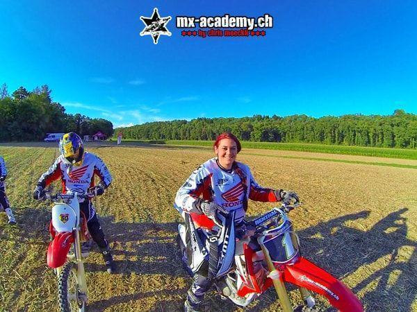 Fahrerin und Fahrer lächeln auf ihren Honda-Motorrädern unter blauem Himmel in die Kamera – Motocross Weihnachtsgeschenk