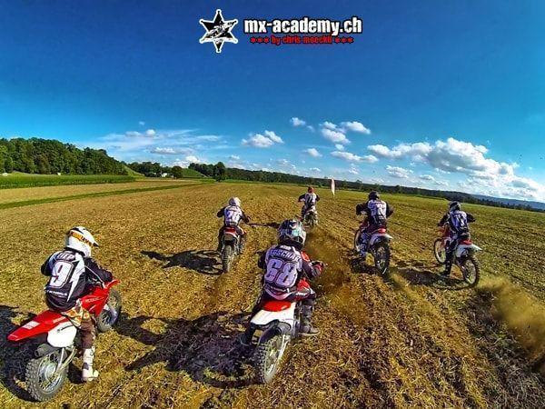 Fahrergruppe von hinten gesehen beim Losfahren über eine weite Erdfläche – Motocross Termine für alle Gruppen