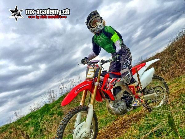 Motorradfahren am Wiesenhang: Startnummer 5 im grünen Trikot auf einer Honda unterwegs