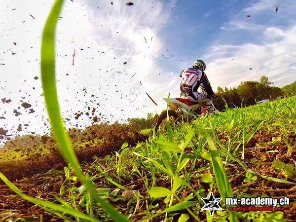 Bodenperspektive aus dem Gras auf den Fahrer mit Startnummer 50, Erde fliegt durch die Luft