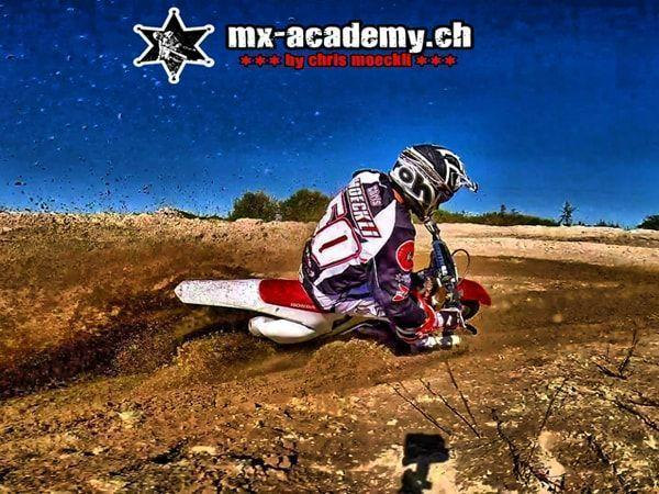 Moto X in Aktion: Fahrer mit Startnummer 50 in tiefer Schräglage, das Hinterrad schleudert Erde hoch