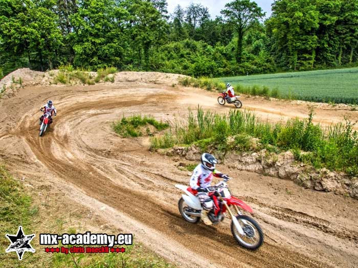 Motocross fahren lernen: Fahrer unterwegs auf der kurvigen Strecke zwischen Wiesen