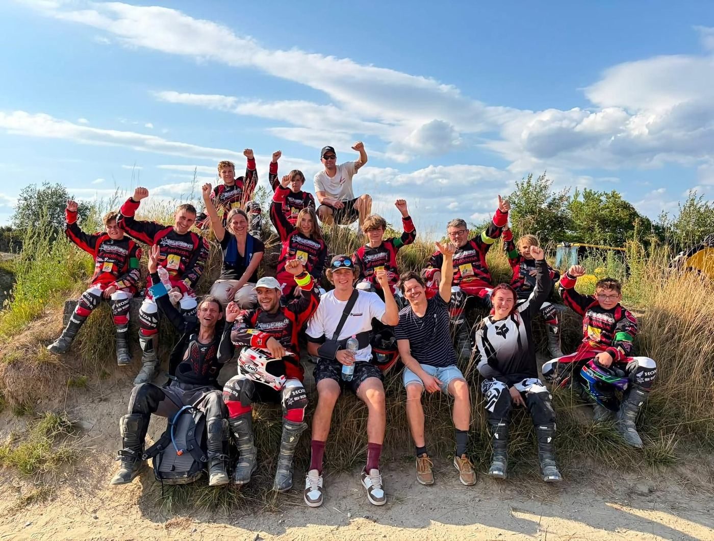 Teamevent ab Deutschland: Gruppe von Fahrerinnen und Fahrern in Motocross-Ausrüstung unter dem Zelt